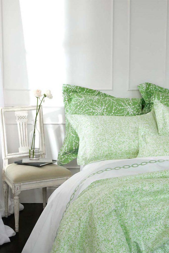 Partial view of a bed with a light green bedding set