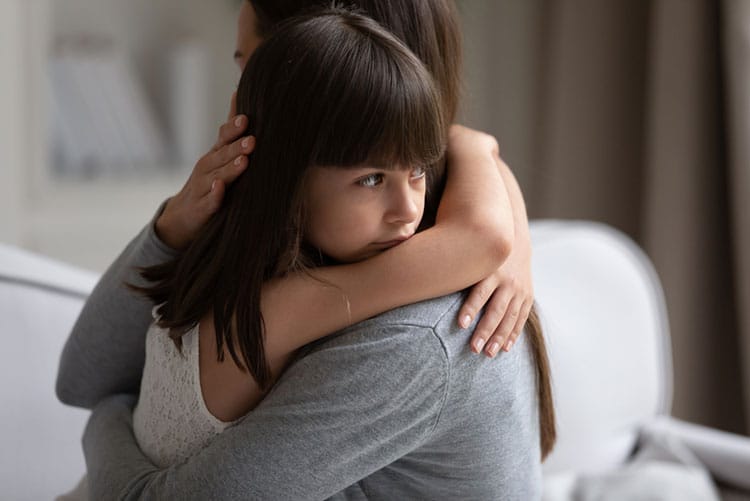 Mother hugging daughter