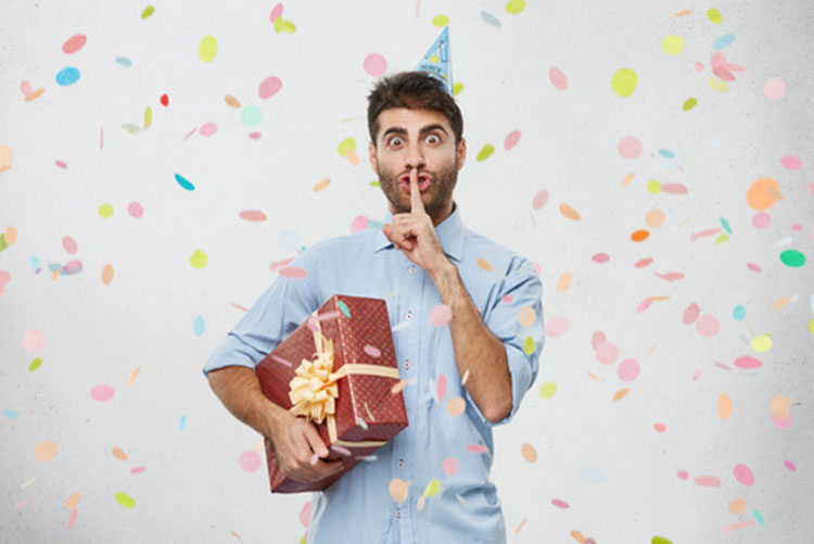 Man carrying a gift and shushing